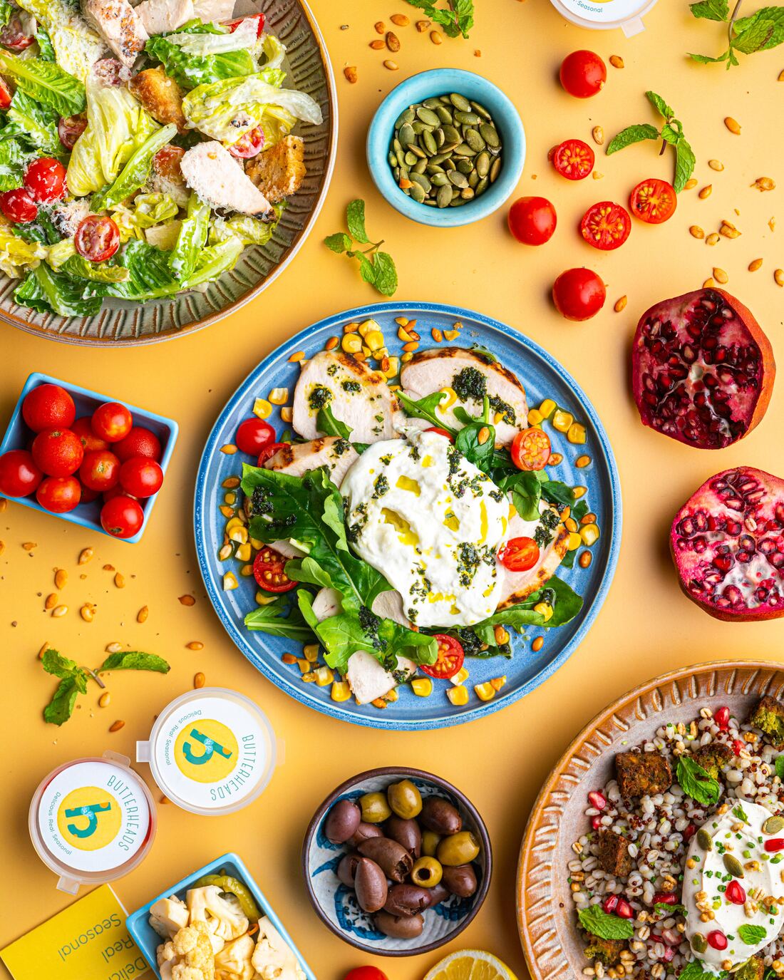 Flat-lay spread of Butterheads salads and grain bowls