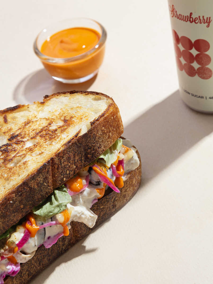 Toasted Butterheads loaded sandwich with pickled onions and chilli sauce, served with kombucha